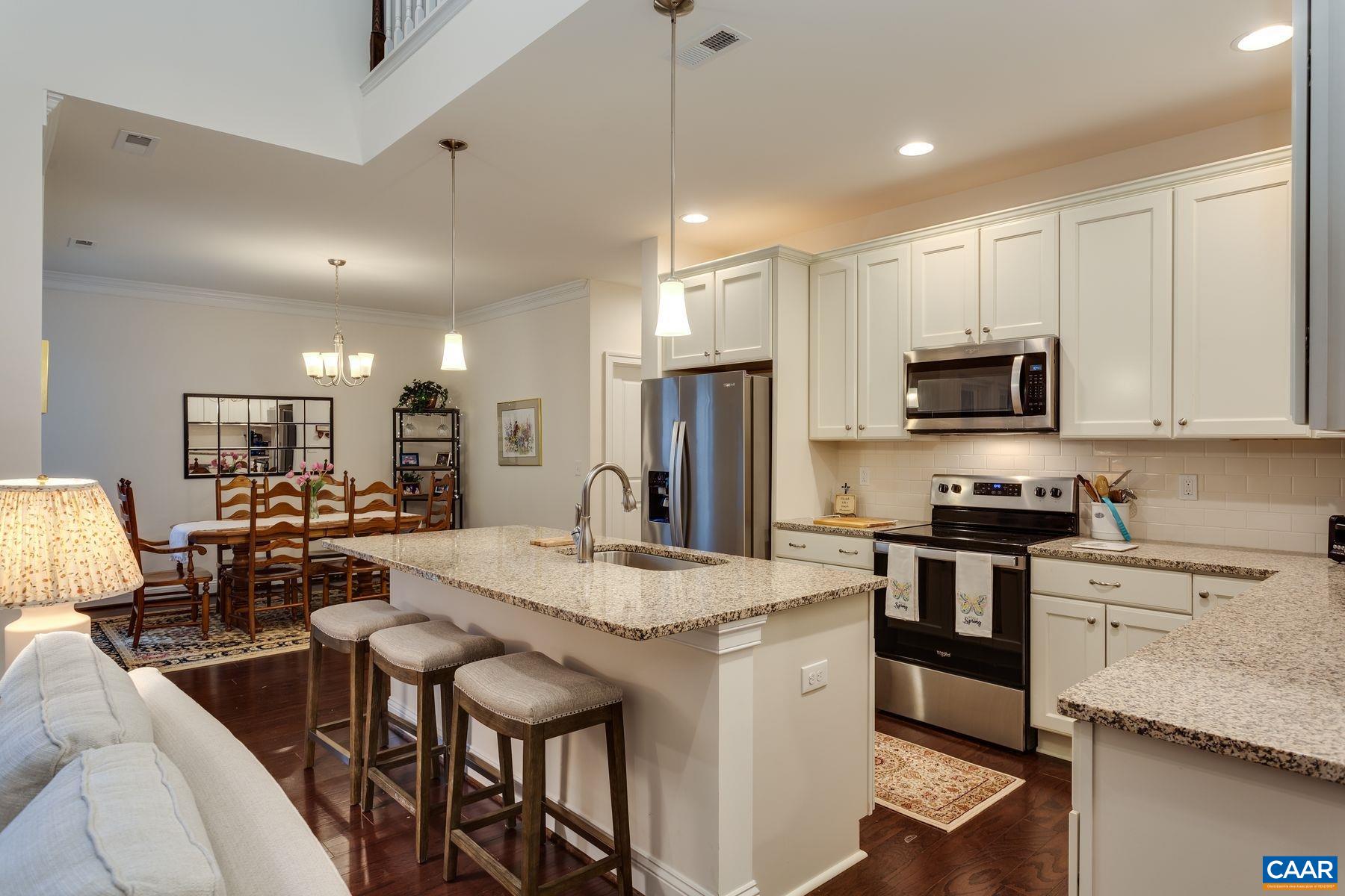 1927 Fowler Street Charlottesville, VA 22901 - Photo 18 of 36 a open kitchen with stainless steel appliances granite countertop a stove refrigerator a sink dishwasher a dining table and chairs with wooden floor