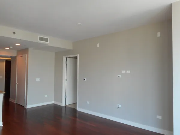 a view of a hallway with wooden floor and windows