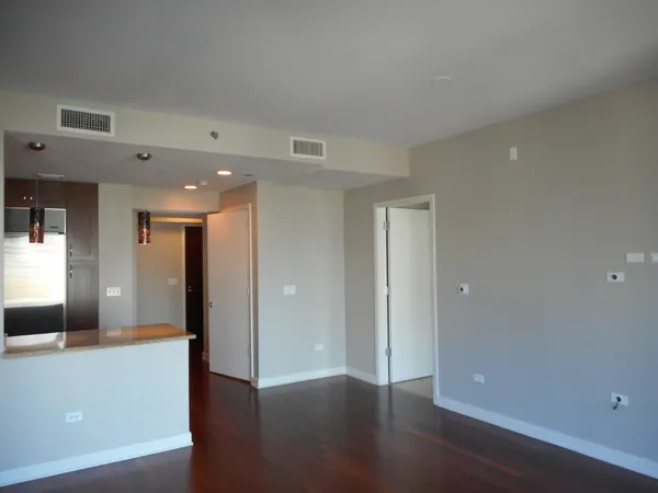 a view of a hallway with wooden floor and windows