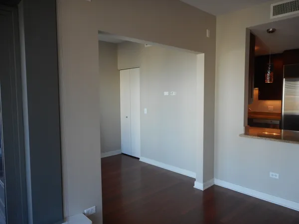 a view of a room with wooden floor and door