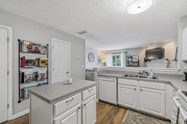 a kitchen with white cabinets and sink