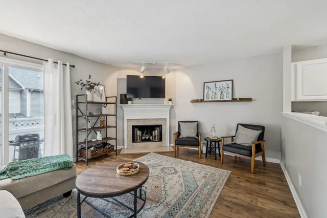 a living room with furniture a fireplace and a flat screen tv