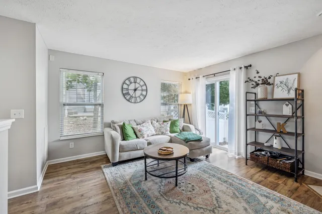 a living room with furniture a rug and a window