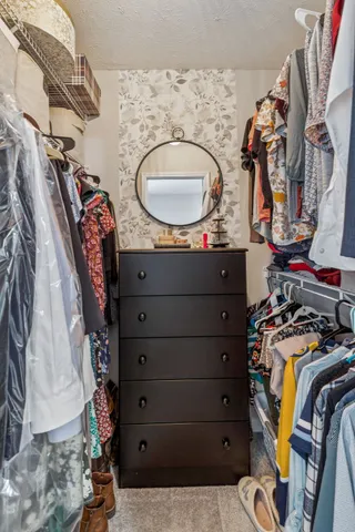 a view of walk in closet with clothes