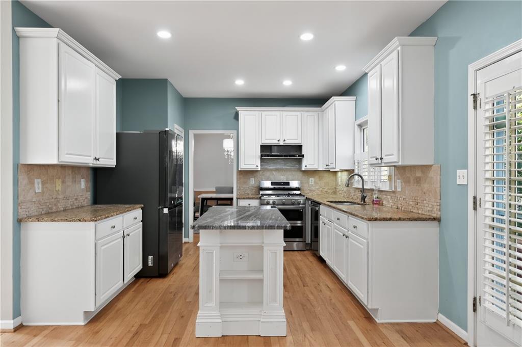 10950 Regal Forest Drive Suwanee, GA 30024 - Photo 11 of 52 a kitchen with stainless steel appliances kitchen island granite countertop a refrigerator stove and sink