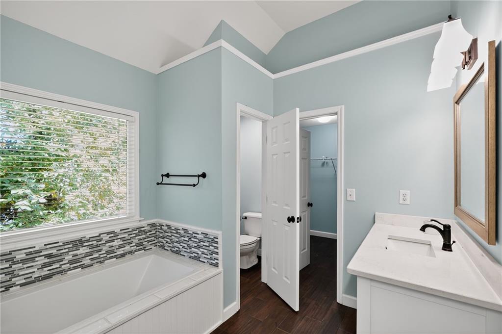 10950 Regal Forest Drive Suwanee, GA 30024 - Photo 36 of 52 a bathroom with a granite countertop sink a toilet and shower