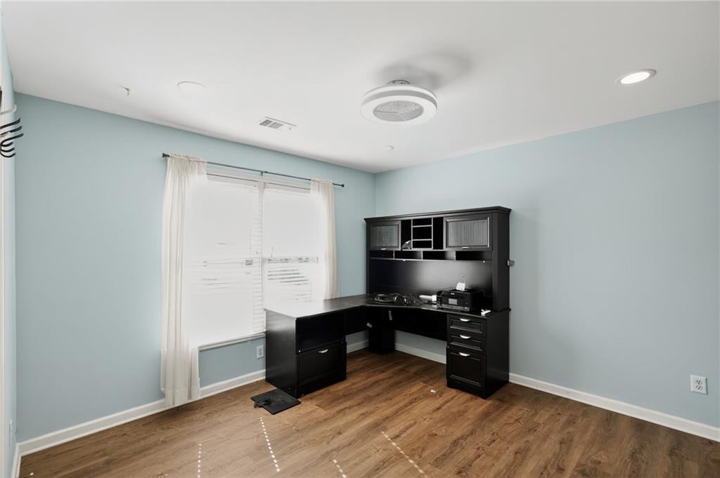 10950 Regal Forest Drive Suwanee, GA 30024 - Photo 43 of 52 a kitchen with cabinets and wooden floor