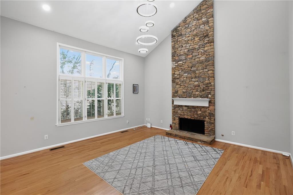 10950 Regal Forest Drive Suwanee, GA 30024 - Photo 6 of 52 wooden floor in an empty room with a fireplace