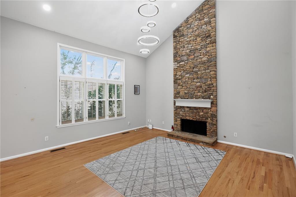 10950 Regal Forest Drive Suwanee, GA 30024 - Photo 9 of 52 wooden floor in an empty room with a fireplace