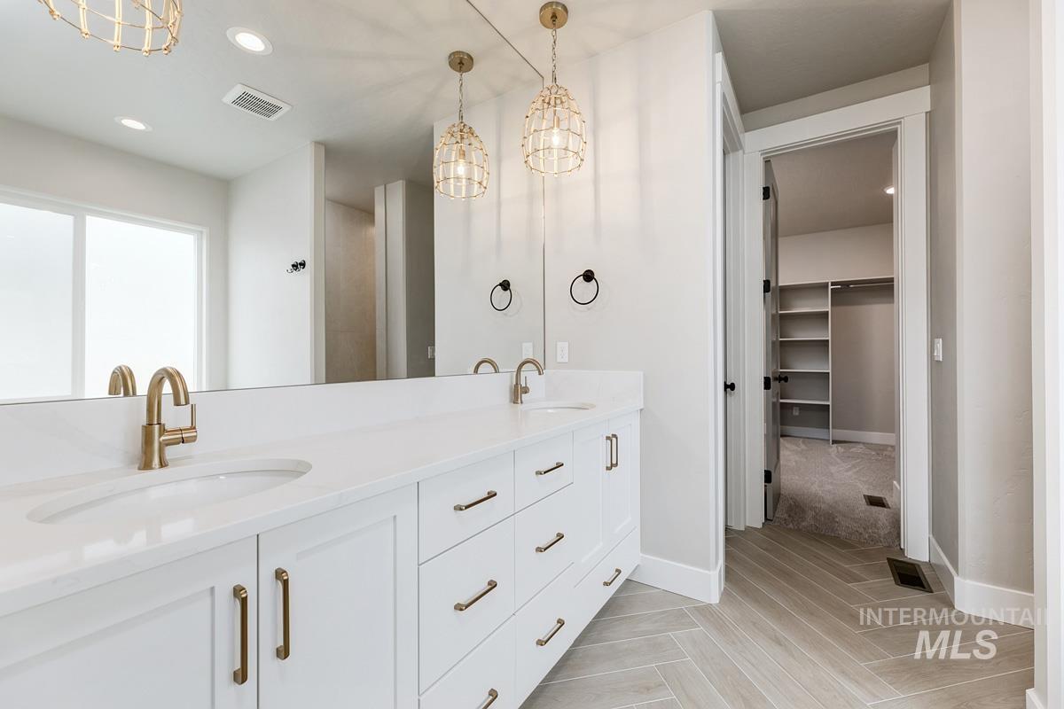 13544 North Ruffed Grouse Way Boise, ID 83714 - Photo 15 of 44 Bathroom featuring recessed lighting, a chandelier, double vanity, a spacious closet, and light wood finished floors