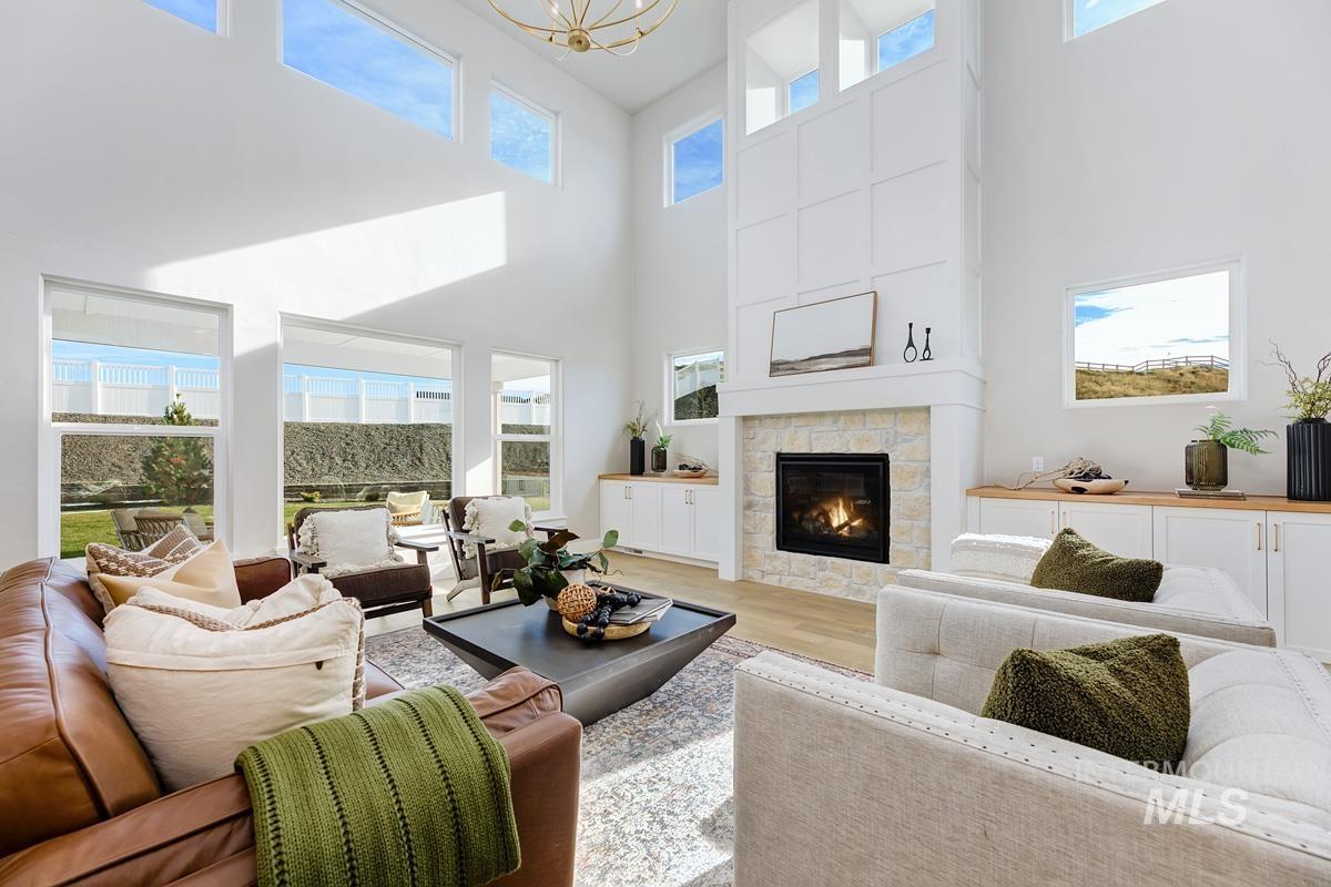 13544 North Ruffed Grouse Way Boise, ID 83714 - Photo 3 of 44 Living area with light wood-type flooring, a fireplace, and a towering ceiling