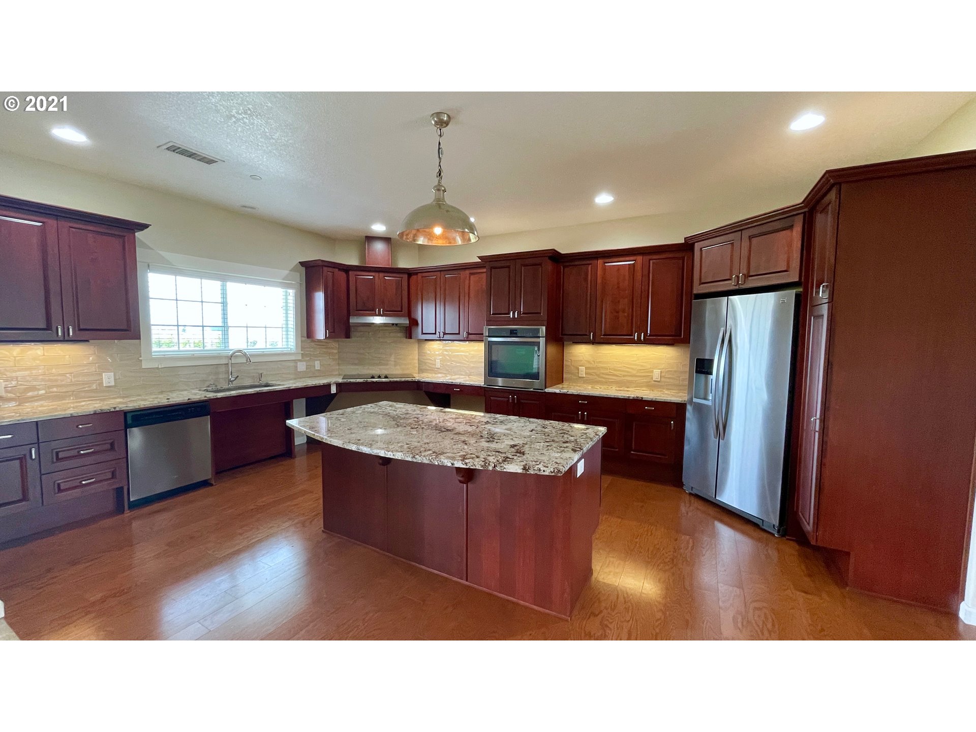 8765 Southwest River Road Hillsboro, OR 97123 - Photo 4 of 31 a kitchen with stainless steel appliances granite countertop a refrigerator a sink dishwasher a stove with wooden cabinets