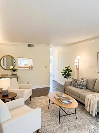 a living room with furniture a rug and a potted plant