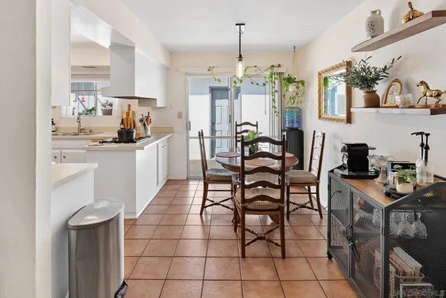 a kitchen with stainless steel appliances a table and chairs in it