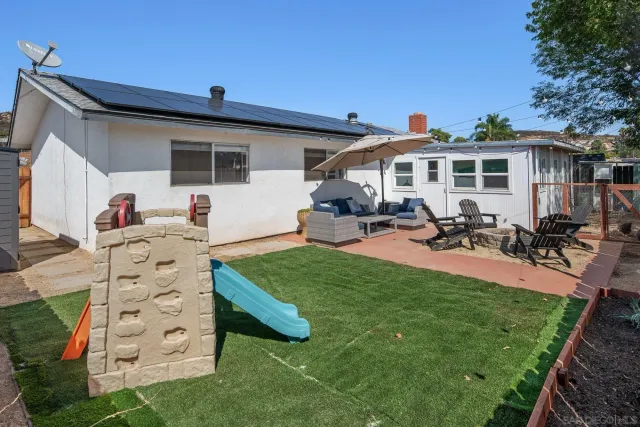 a view of a house with backyard sitting area and garden
