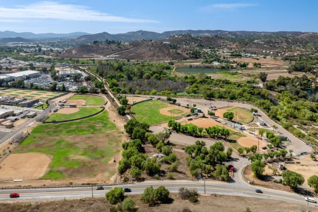 an aerial view of residential houses with outdoor space and parking