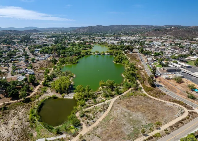 an aerial view of residential houses with outdoor space and trees