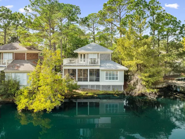 a kitchen with stainless steel appliances kitchen island granite countertop a dining table chairs and a refrigerator