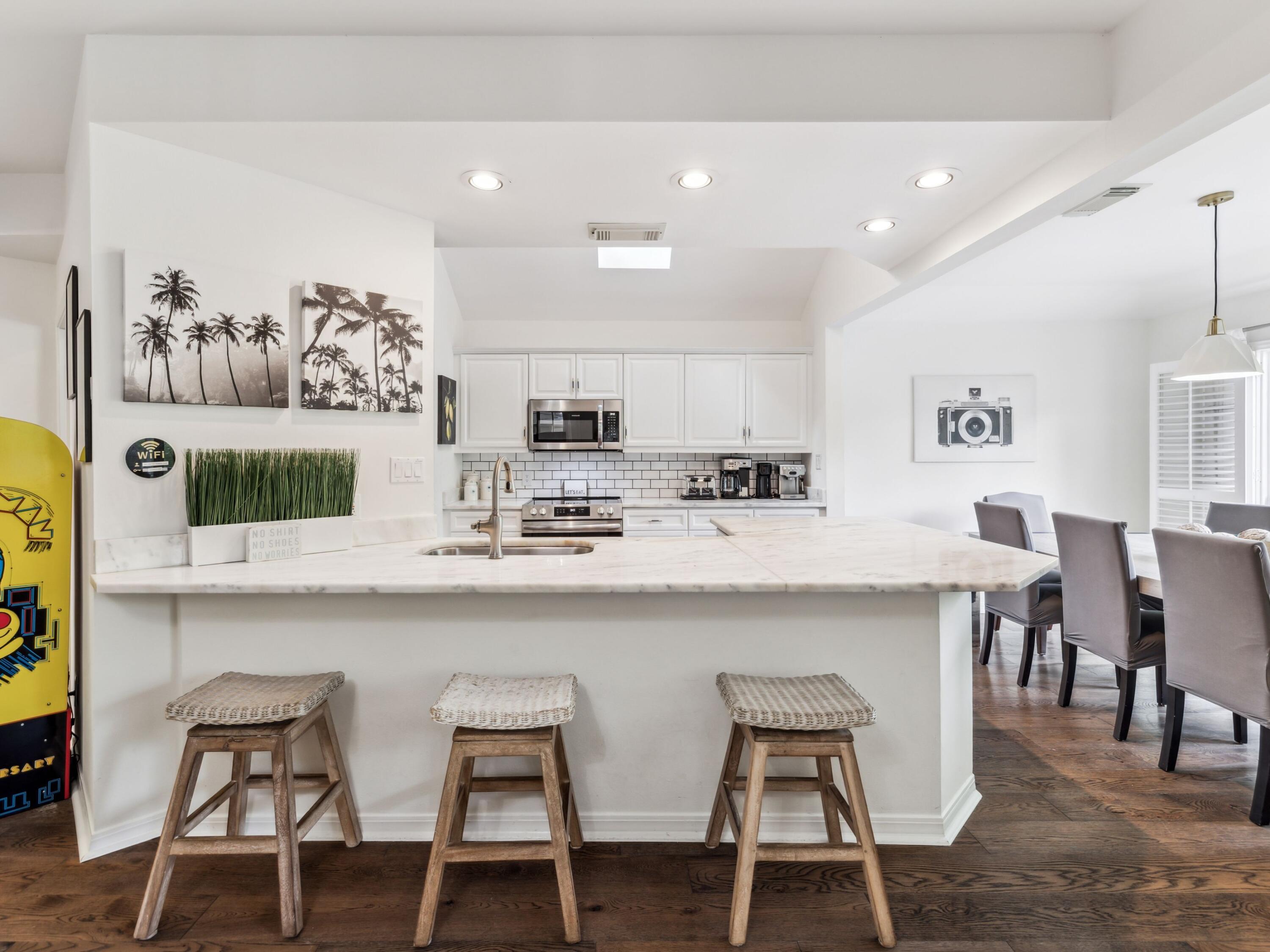 8855 Baypine Drive Miramar Beach, FL 32550 - Photo 5 of 49 a kitchen with stainless steel appliances kitchen island granite countertop a dining table chairs and a refrigerator