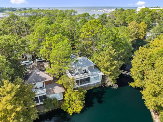 a kitchen with stainless steel appliances kitchen island granite countertop a stove a sink a refrigerator a microwave oven with white cabinets and wooden floor