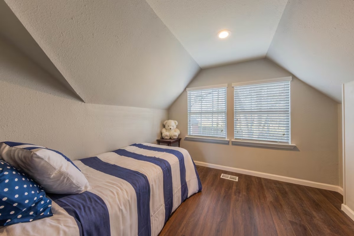 1212 North Main Street Elgin, TX 78621 - Photo 13 of 31 Bedroom featuring vaulted ceiling, a textured ceiling, and dark wood-type flooring