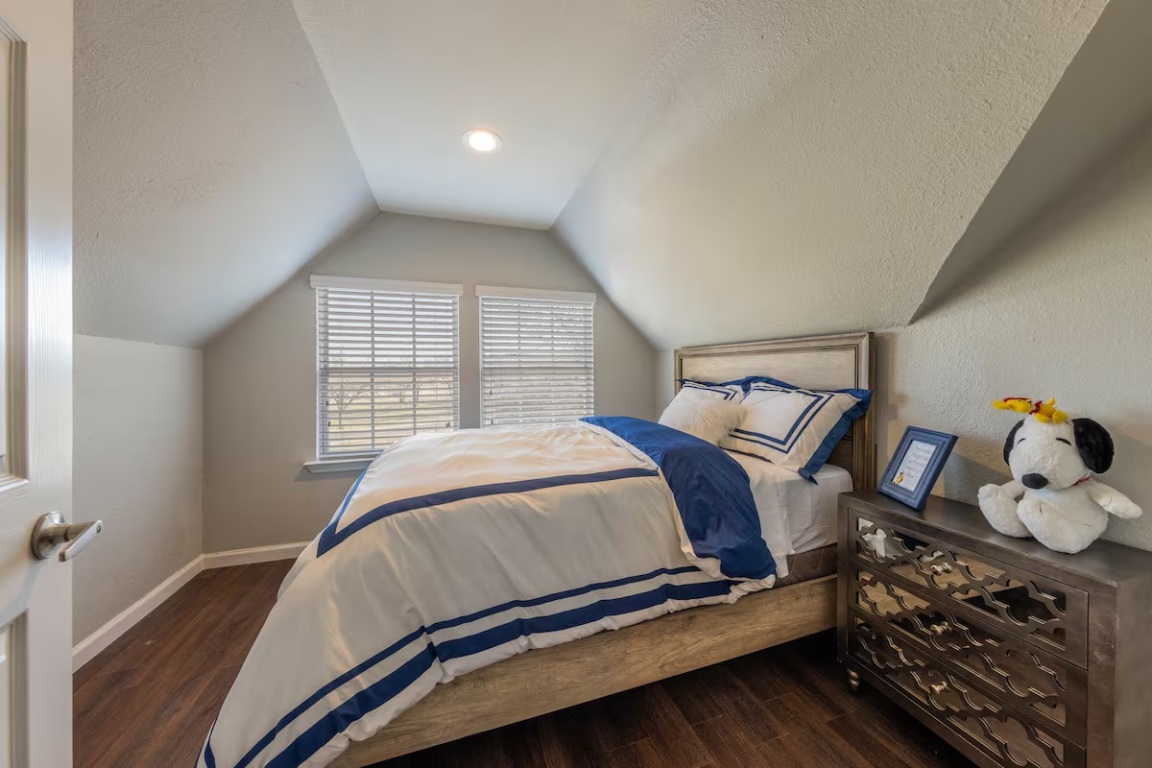 1212 North Main Street Elgin, TX 78621 - Photo 15 of 31 Bedroom featuring dark wood-style floors, lofted ceiling, and a textured ceiling