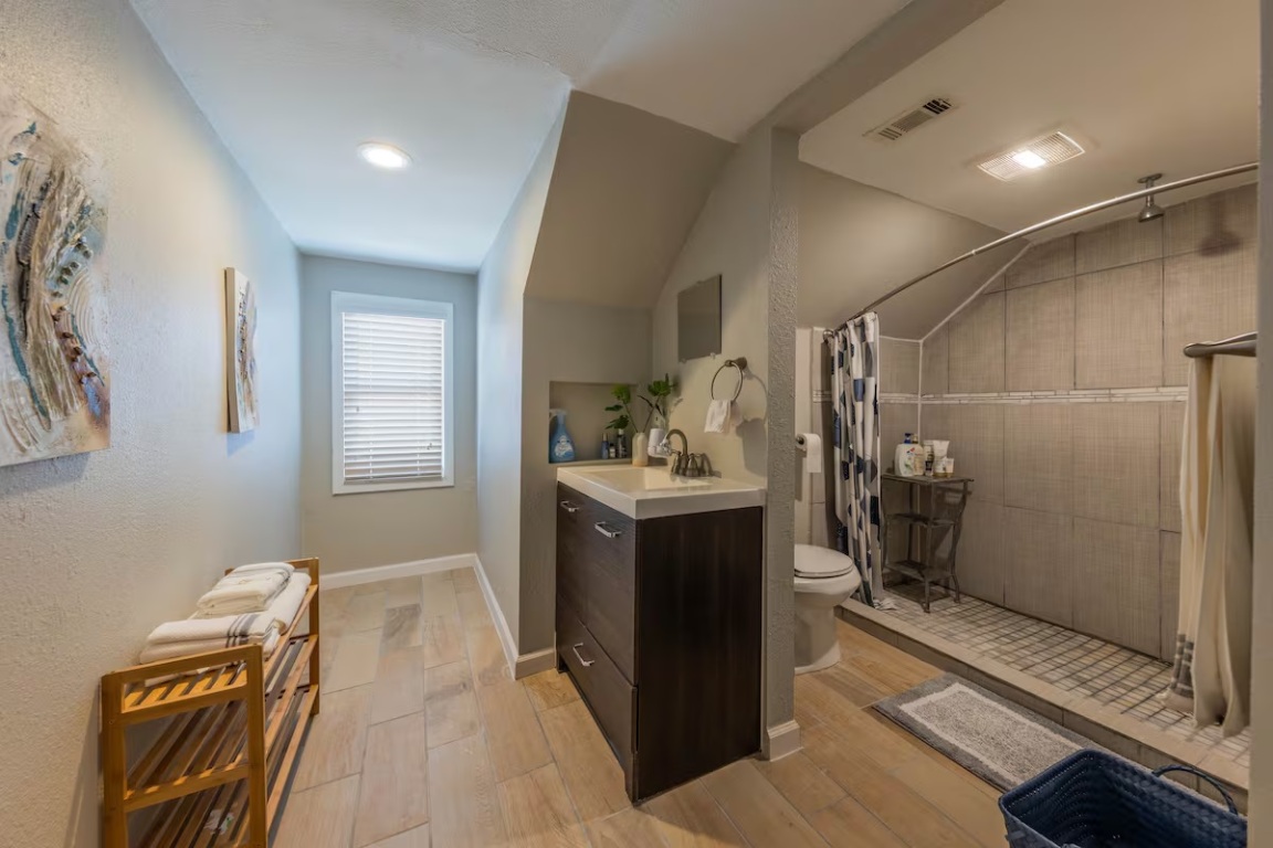 1212 North Main Street Elgin, TX 78621 - Photo 24 of 31 Full bathroom featuring vanity, a tile shower, lofted ceiling, and light wood-style floors