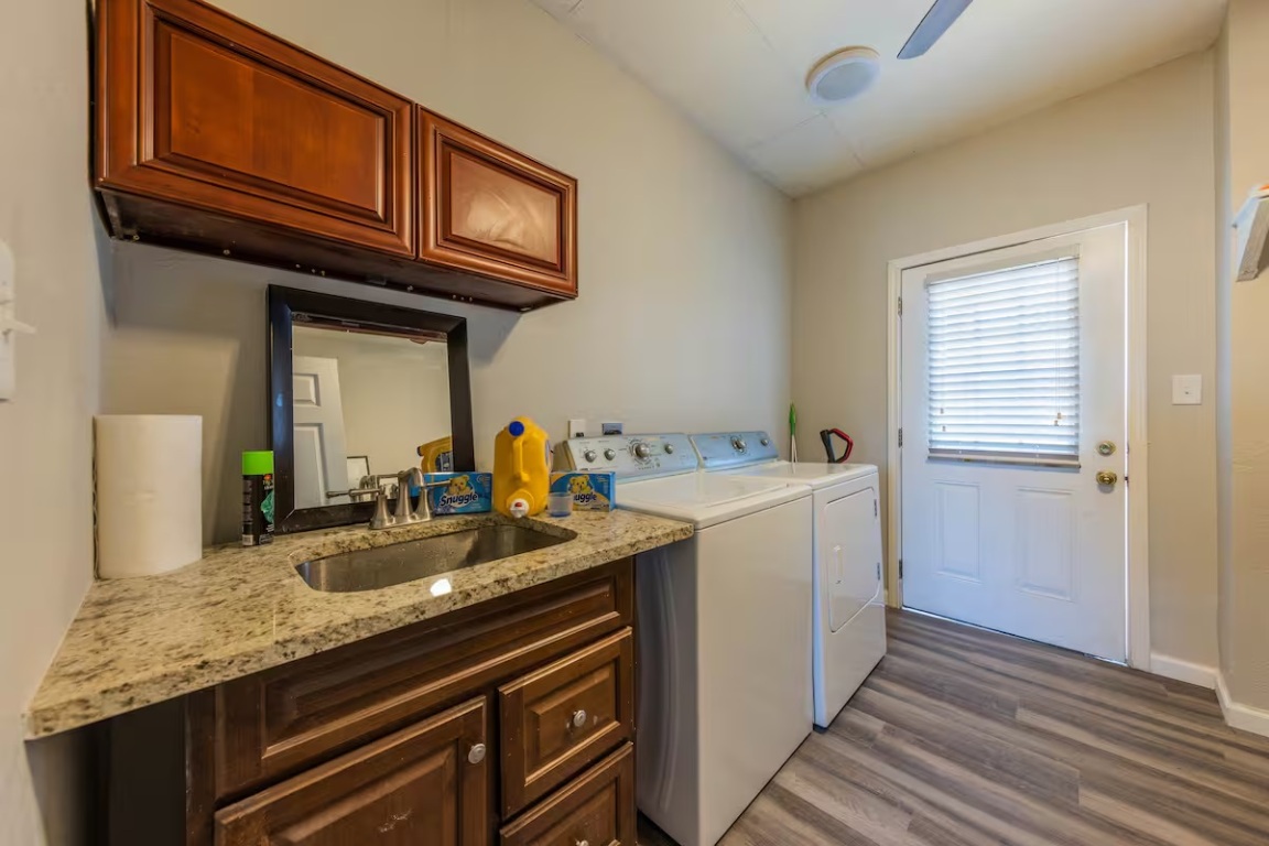 1212 North Main Street Elgin, TX 78621 - Photo 26 of 31 Laundry room featuring washing machine and dryer, dark wood-style flooring, and cabinet space