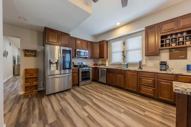 a kitchen with stainless steel appliances wooden cabinets a stove and a refrigerator
