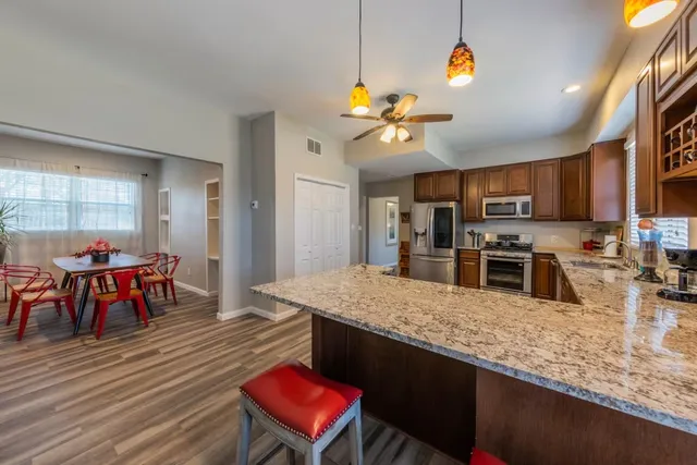 a kitchen with a stove a kitchen island a dining table and chairs
