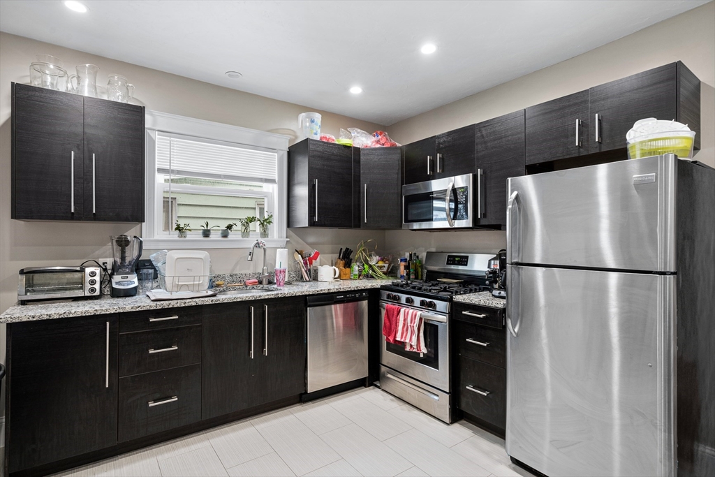 79 Saxton Street, Unit 3 Boston, MA 02125 - Photo 9 of 12 a kitchen with stainless steel appliances a refrigerator sink and cabinets