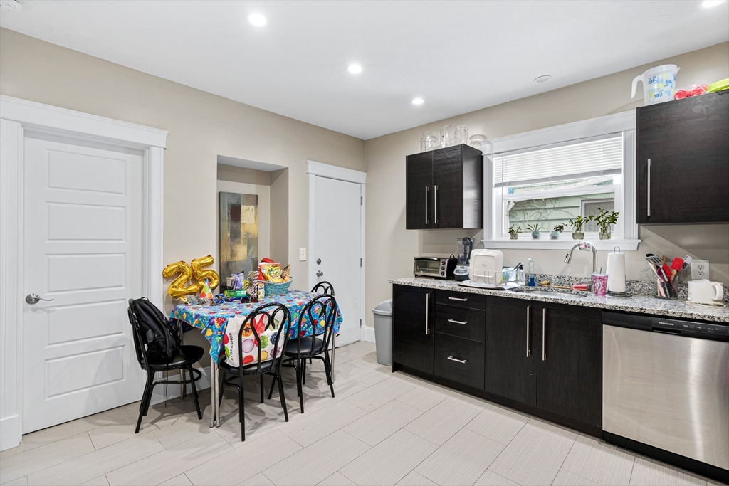 79 Saxton Street, Unit 3 Boston, MA 02125 - Photo 10 of 12 a kitchen with stainless steel appliances granite countertop a sink counter space and dining table