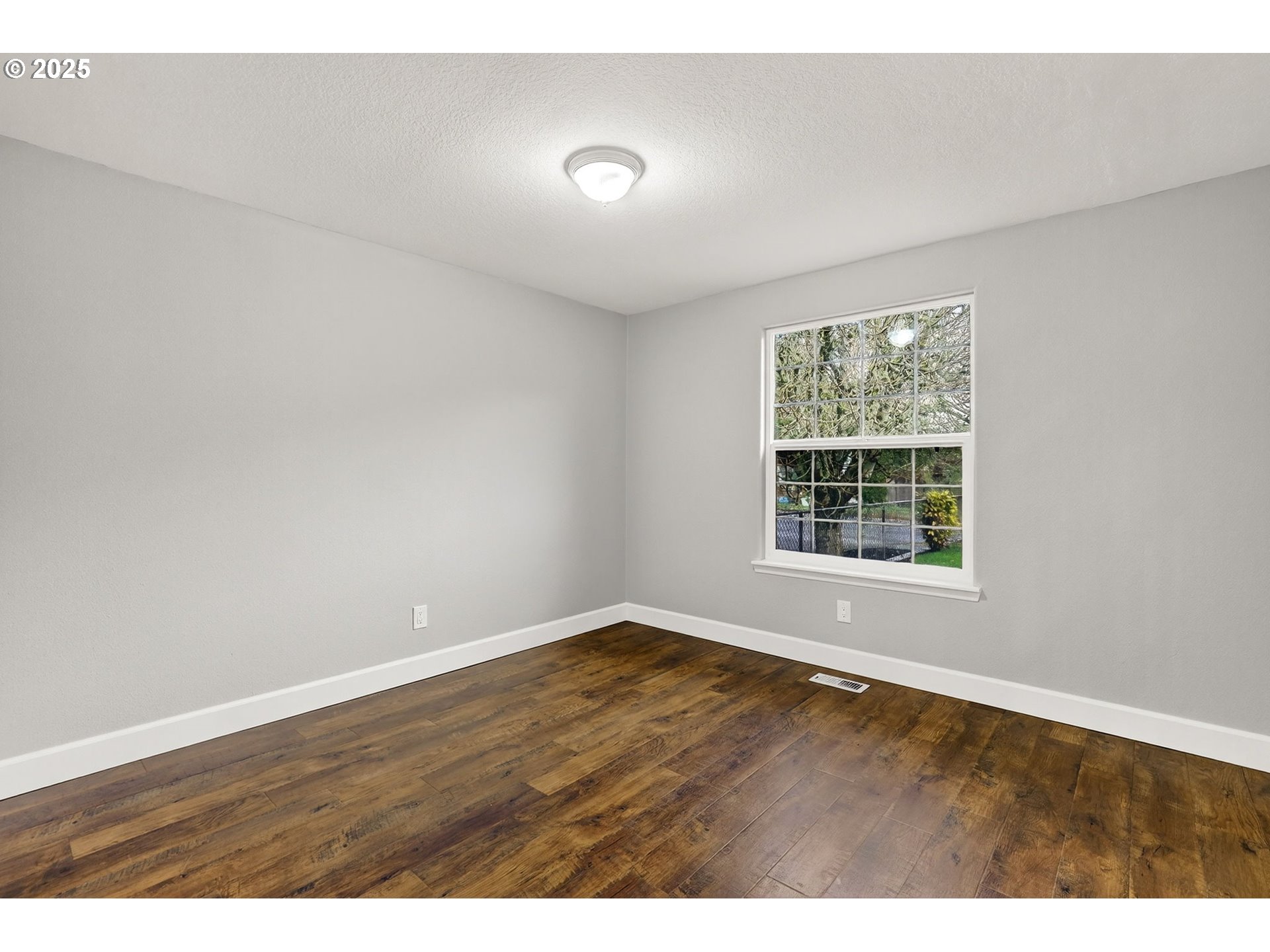 5118 Northeast Jarrett Street Portland, OR 97218 - Photo 14 of 46 an empty room with wooden floor and windows