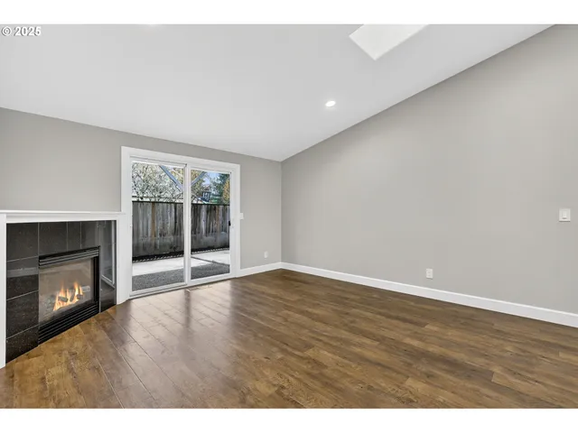 a view of an empty room with a fireplace and a window