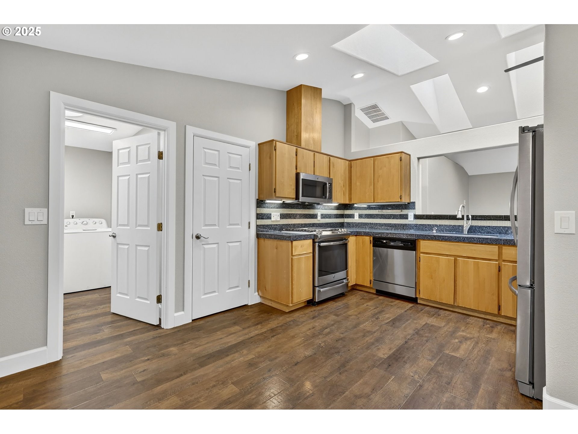 5118 Northeast Jarrett Street Portland, OR 97218 - Photo 7 of 46 a kitchen with stainless steel appliances a sink and wooden floors