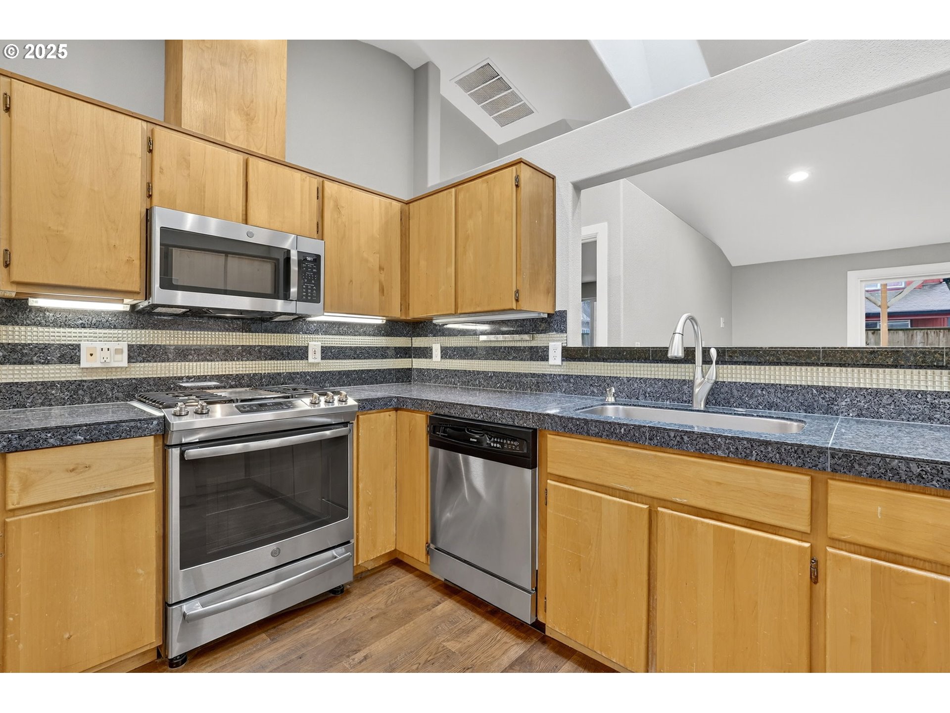 5118 Northeast Jarrett Street Portland, OR 97218 - Photo 9 of 46 a kitchen with stainless steel appliances granite countertop a stove a microwave and a sink
