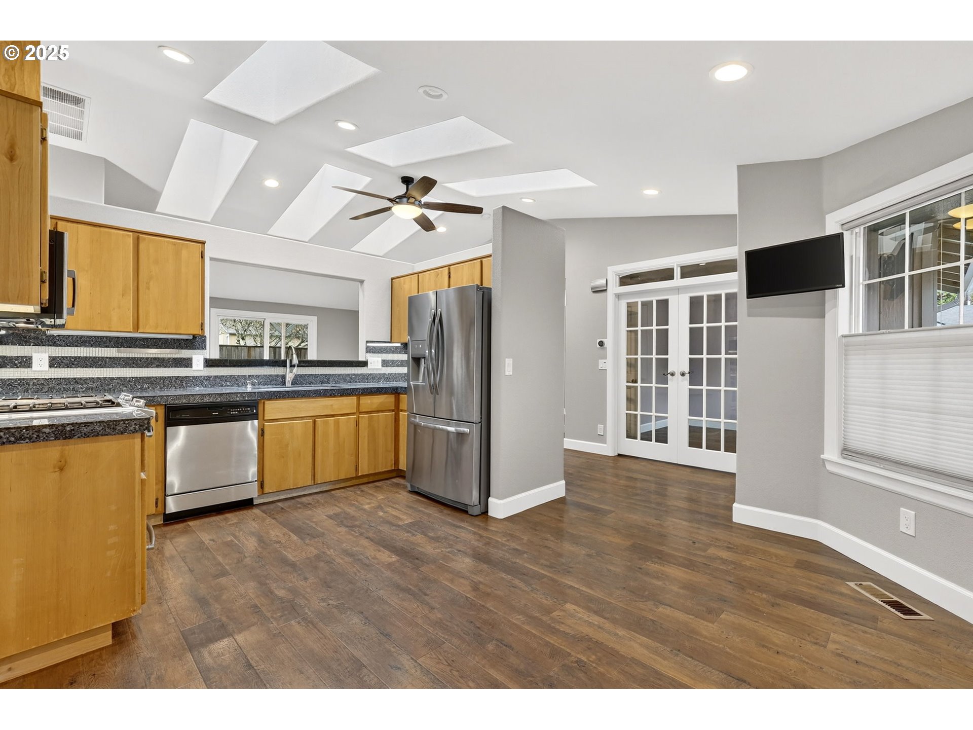 5118 Northeast Jarrett Street Portland, OR 97218 - Photo 10 of 46 a kitchen with stainless steel appliances kitchen island granite countertop a refrigerator and a stove top oven
