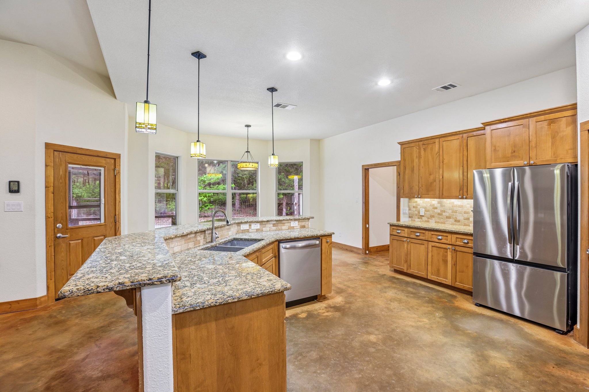 267 Corral Road Smithville, TX 78957 - Photo 17 of 40 Kitchen featuring light wood cabinetry, stainless steel appliances, and a granite-topped island with a double basin sink