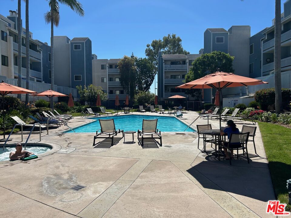 8162 Manitoba Street, Unit 111 Playa del Rey, CA 90293 - Photo 1 of 17 a view of a patio with a table and chairs under an umbrella