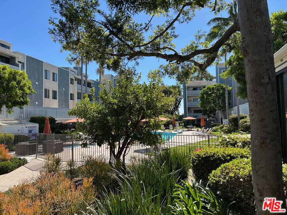 8162 Manitoba Street, Unit 111 Playa del Rey, CA 90293 - Photo 15 of 17 a view of backyard of house with outdoor seating and green space