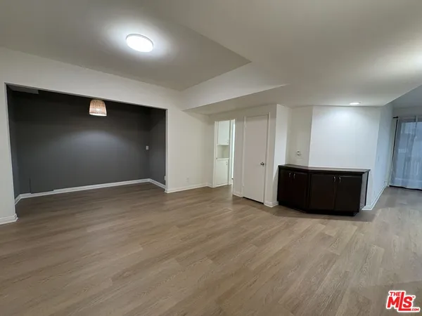 a view of an empty room with wooden floor