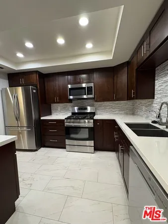 a kitchen with stainless steel appliances a refrigerator sink and microwave