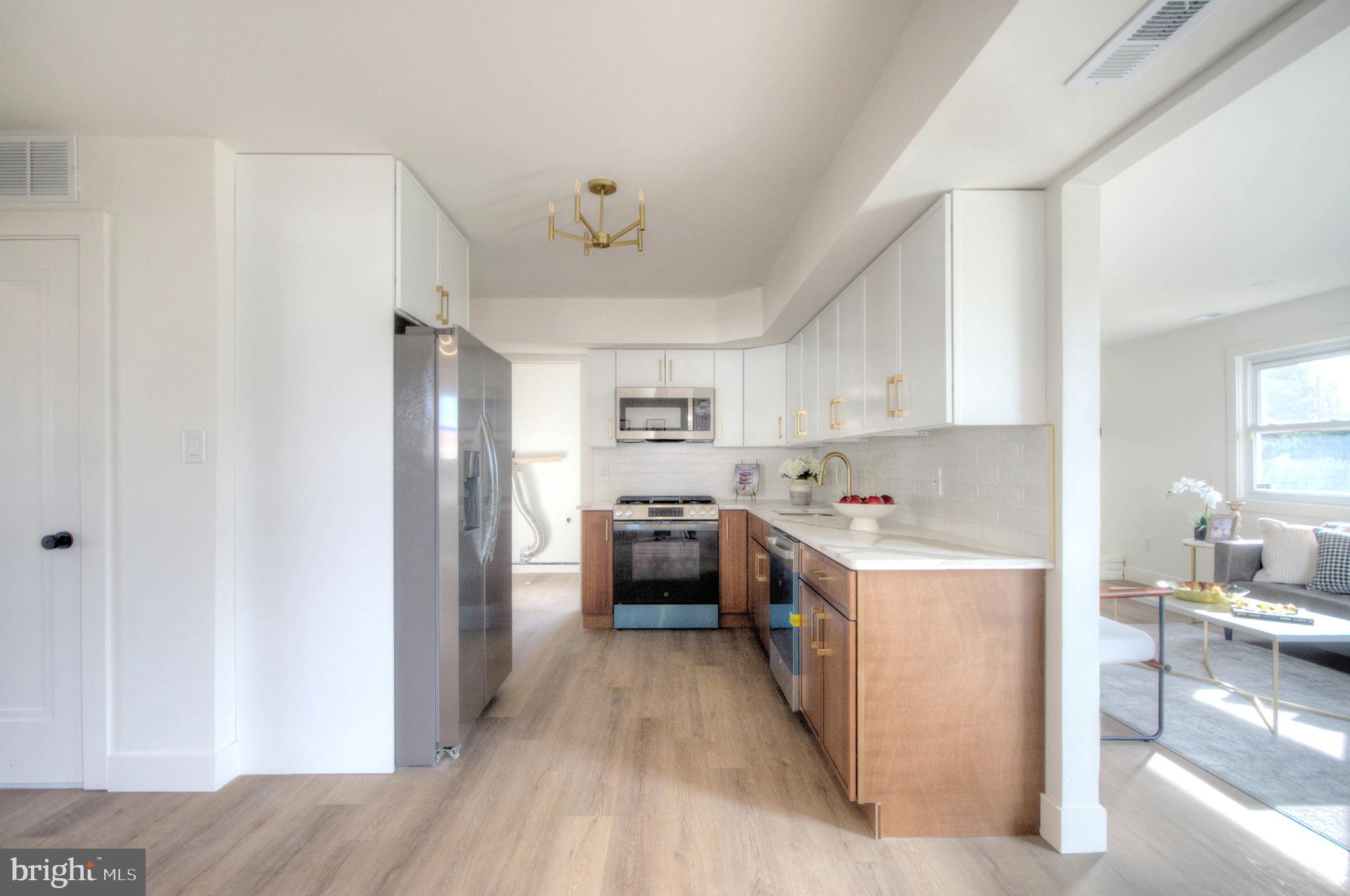 921 North Beecham Road Williamstown, NJ 08094 - Photo 13 of 43 a kitchen with a refrigerator a stove top oven a sink dishwasher and white cabinets with wooden floor