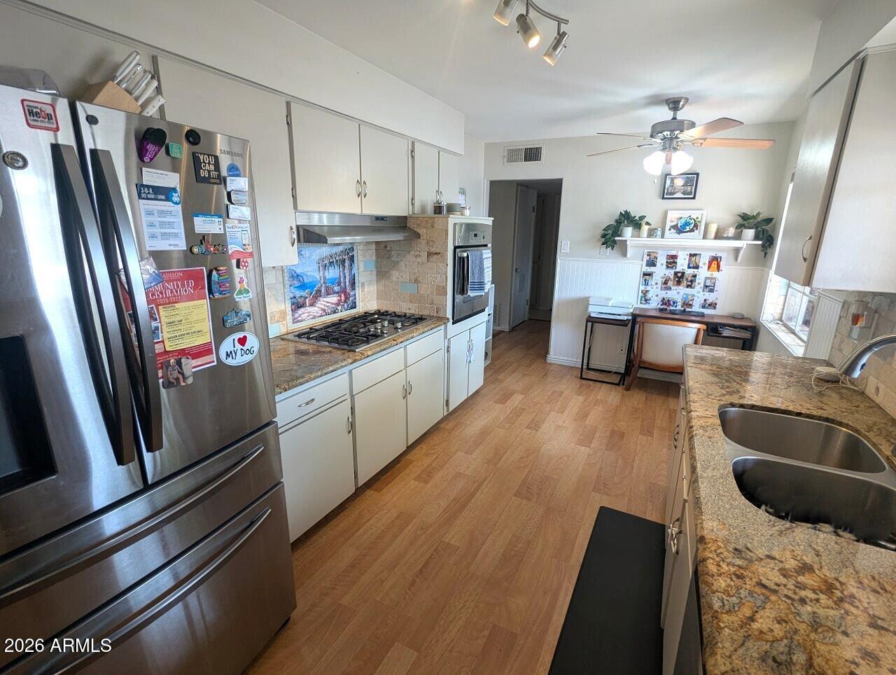2240 West Berridge Lane Phoenix, AZ 85015 - Photo 6 of 30 a kitchen with granite countertop stainless steel appliances a sink stove refrigerator and cabinets