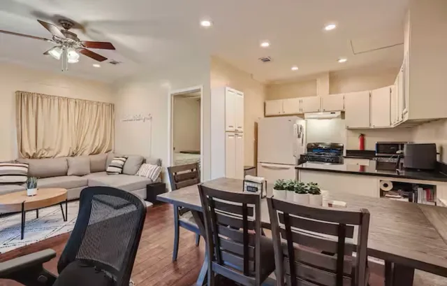 a living room with stainless steel appliances kitchen island granite countertop furniture and a refrigerator