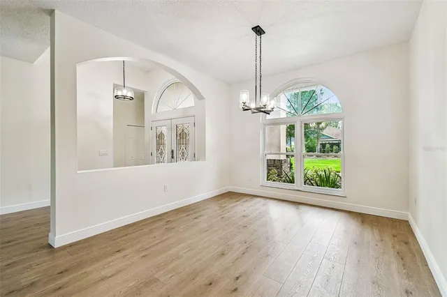 a view of a livingroom with wooden floor a fireplace and windows