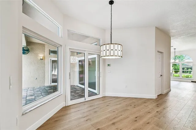 an empty room with wooden floor closet and windows