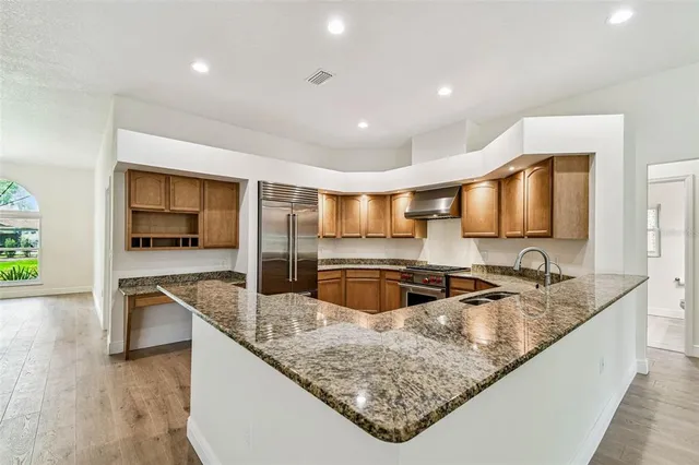 an empty room with wooden floor and chandelier fan