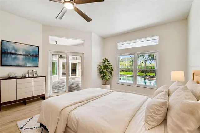 a view of a patio with a table and chairs under an umbrella with large trees