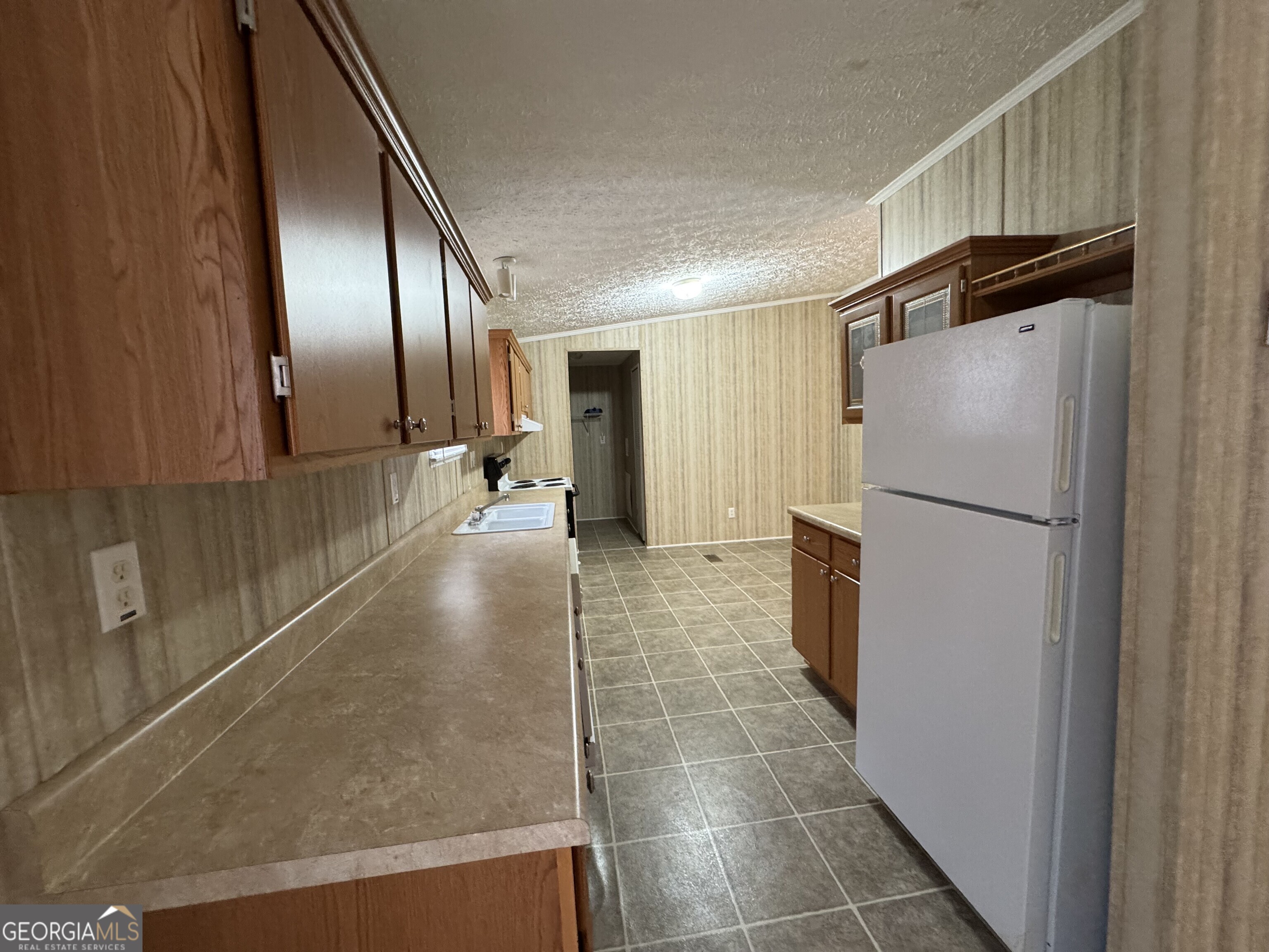 2278 Providence Church Road Lavonia, GA 30553 - Photo 9 of 16 a view of a refrigerator in kitchen and an empty room with wooden floor